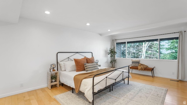 bedroom with hardwood / wood-style floors, baseboards, and visible vents
