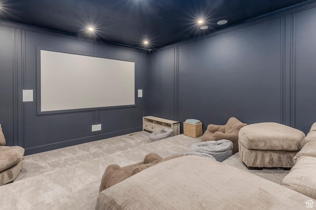 carpeted cinema featuring a decorative wall, ornamental molding, and recessed lighting