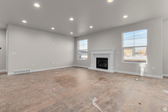 692 W Junegrass Ln, Stansbury Park, UT 84074 - unfurnished living room with a glass covered fireplace, recessed lighting, visible vents, and baseboards