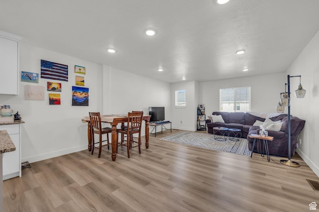 dining room featuring light wood-style flooring, baseboards, and recessed lighting