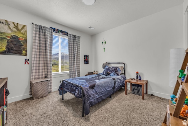 carpeted bedroom featuring visible vents, baseboards, and a textured ceiling