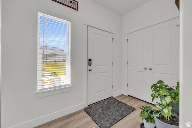 foyer entrance featuring light wood-type flooring and baseboards