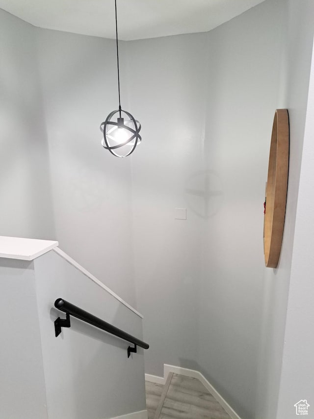 staircase featuring baseboards and wood finished floors