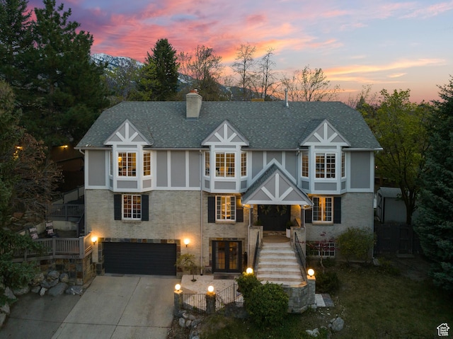 3338 E Creek Rd, Cottonwood Heights, UT 84121 - tudor-style house featuring a garage, french doors, driveway, a chimney, and a shingled roof