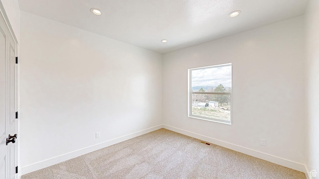 carpeted spare room with visible vents, baseboards, and recessed lighting