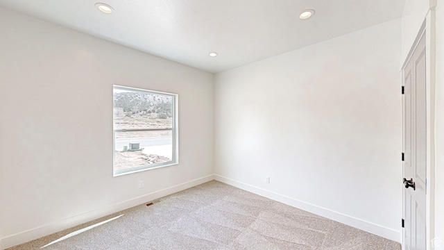 unfurnished room featuring visible vents, baseboards, recessed lighting, and light carpet