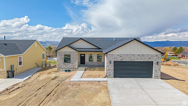 modern farmhouse with concrete driveway, roof with shingles, a mountain view, board and batten siding, and a garage