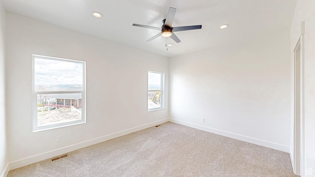 unfurnished room with recessed lighting, visible vents, light colored carpet, and baseboards