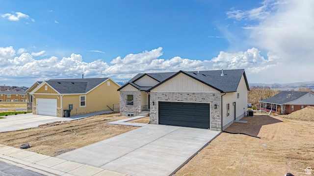 view of front of home featuring board and batten siding, an attached garage, a residential view, and concrete driveway