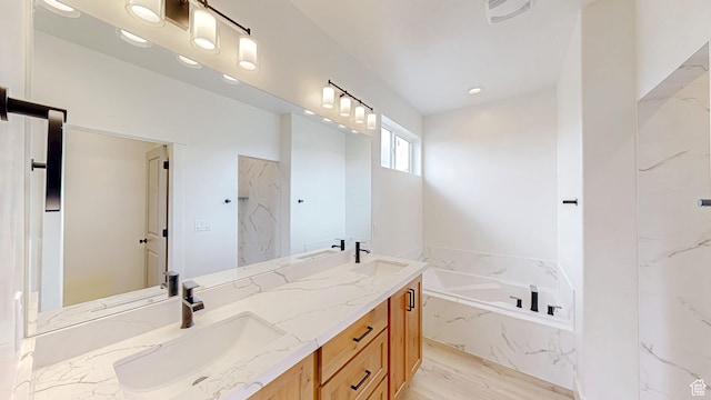 full bathroom featuring a garden tub, double vanity, a sink, and wood finished floors
