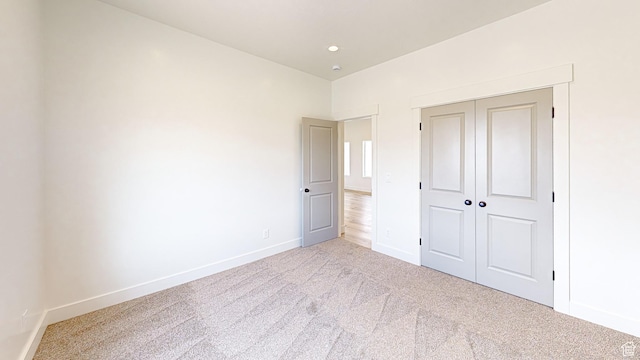 unfurnished bedroom featuring a closet, baseboards, recessed lighting, and carpet flooring