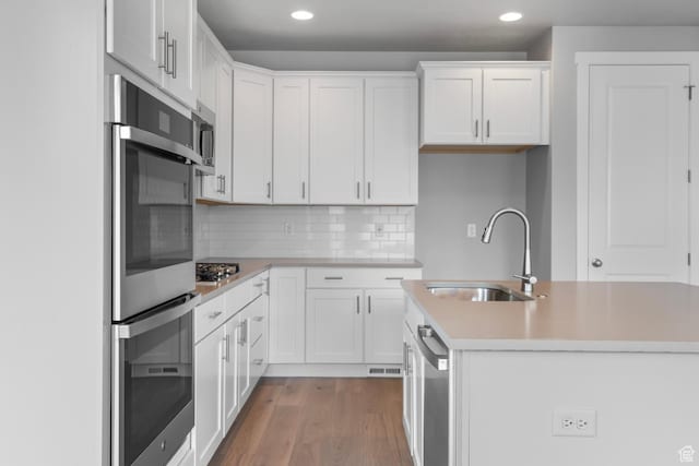 11888 S Golden Pine Ln, Riverton, UT 84065 - kitchen featuring a sink, light countertops, an island with sink, white cabinetry, and wood finished floors
