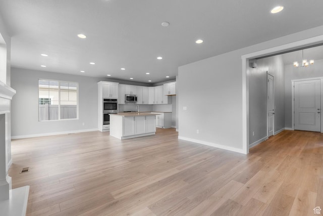 11888 S Golden Pine Ln, Riverton, UT 84065 - unfurnished living room featuring light wood finished floors, baseboards, visible vents, and recessed lighting