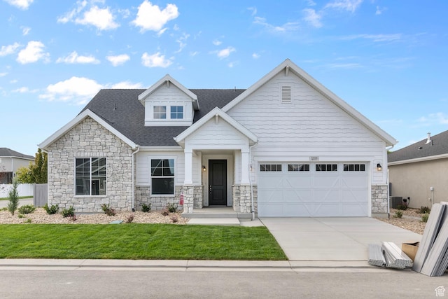11888 S Golden Pine Ln, Riverton, UT 84065 - craftsman inspired home with driveway, stone siding, an attached garage, a front yard, and a shingled roof
