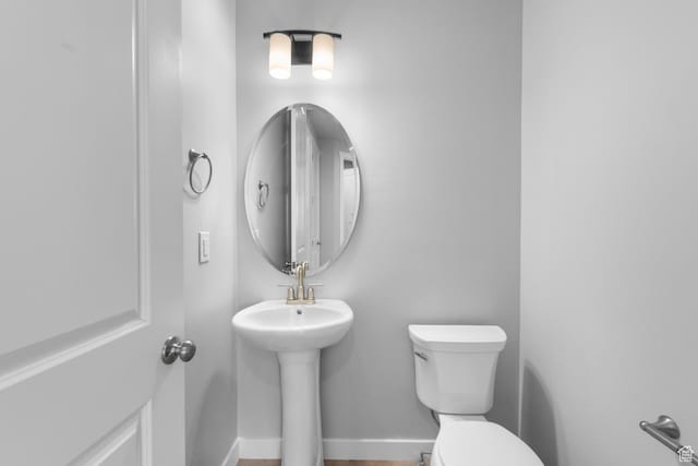 bathroom with baseboards and toilet