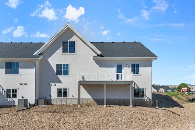 back of property featuring stairway, cooling unit, and stucco siding
