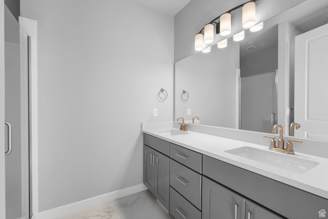 full bathroom featuring baseboards, marble finish floor, a sink, and a stall shower