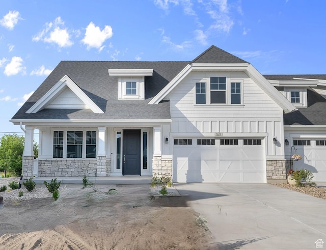 3622 W Harvest Gold Way, Riverton, UT 84065 - view of front of home featuring stone siding, covered porch, driveway, roof with shingles, and a garage