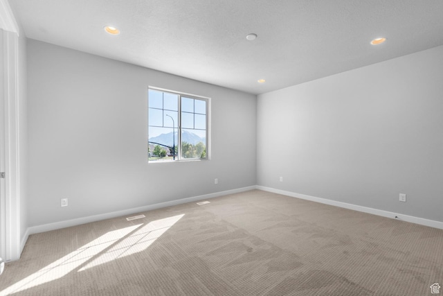 empty room with light colored carpet, baseboards, visible vents, and recessed lighting