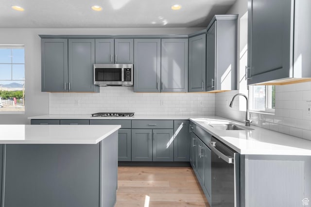 kitchen with light wood-style floors, recessed lighting, appliances with stainless steel finishes, light countertops, and a sink