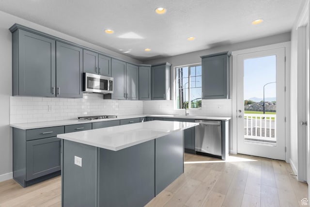kitchen with light countertops, light wood-style flooring, and stainless steel appliances