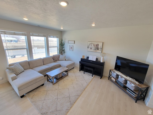 living room featuring baseboards, recessed lighting, wood finished floors, and a textured ceiling