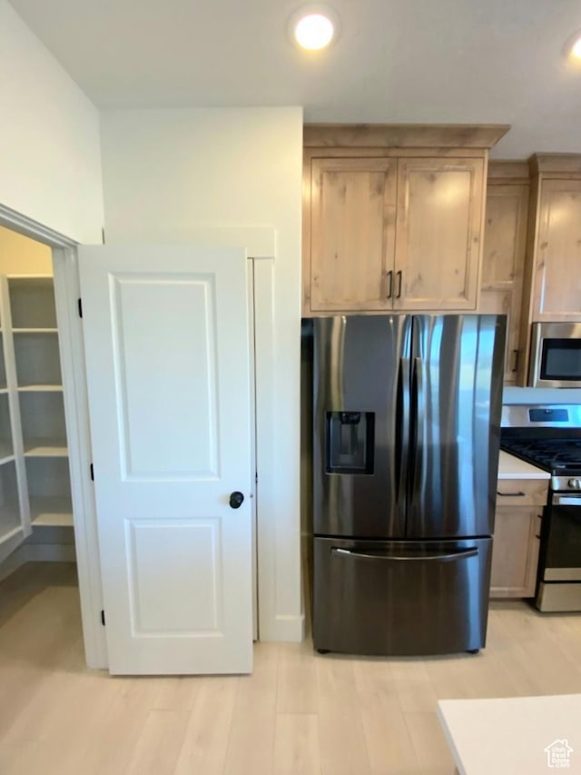 kitchen featuring light wood-type flooring, recessed lighting, light countertops, and stainless steel appliances