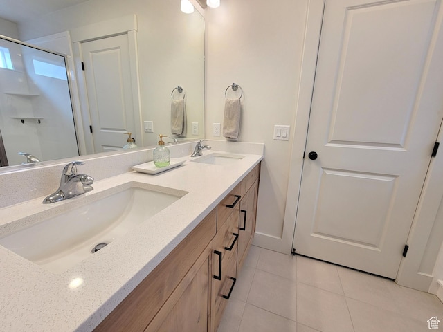 full bathroom featuring a shower, tile patterned floors, double vanity, and a sink