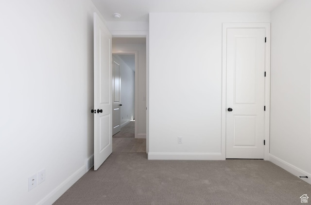 unfurnished bedroom with carpet flooring and baseboards