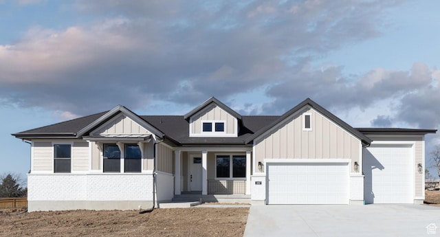 modern farmhouse featuring board and batten siding, an attached garage, brick siding, and concrete driveway