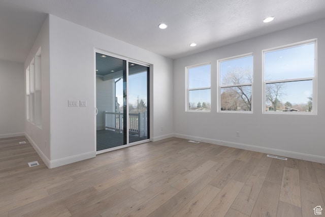 empty room with recessed lighting, light wood-style flooring, baseboards, and visible vents