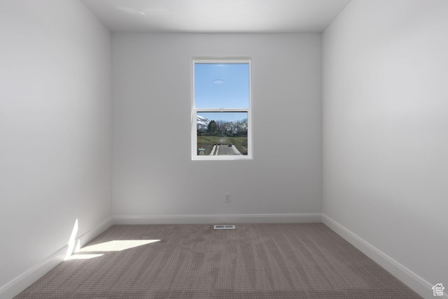 carpeted spare room with baseboards