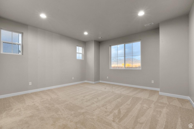 spare room with visible vents, baseboards, recessed lighting, and light carpet