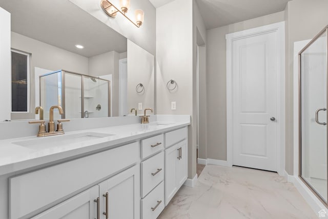 full bathroom with double vanity, marble finish floor, a sink, and a stall shower
