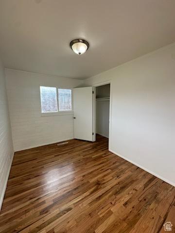 unfurnished bedroom with a closet and wood finished floors