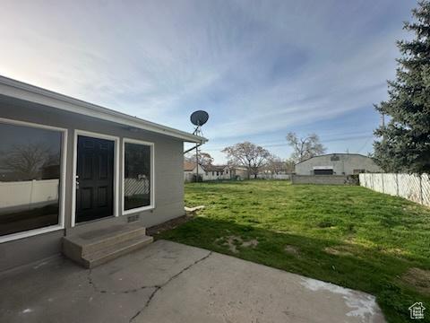 view of yard with entry steps, fence, and a patio