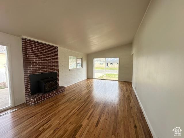 unfurnished living room featuring lofted ceiling, baseboards, and wood finished floors