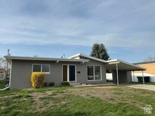 ranch-style house with a carport, a front lawn, and concrete driveway