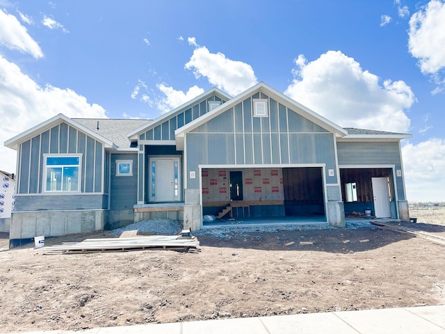 view of front of house with board and batten siding, driveway, roof with shingles, and a garage