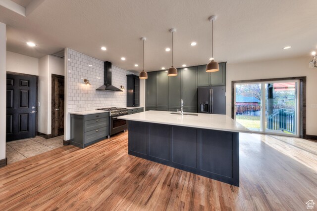 284 W Mcgill Blvd, Moab, UT 84532 - kitchen featuring fridge with ice dispenser, high end range, light countertops, backsplash, and wall chimney exhaust hood