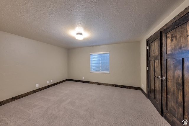 284 W Mcgill Blvd, Moab, UT 84532 - unfurnished bedroom with visible vents, light colored carpet, baseboards, and a textured ceiling