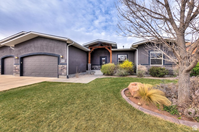 view of front of property with a garage, stucco siding, stone siding, a front lawn, and driveway