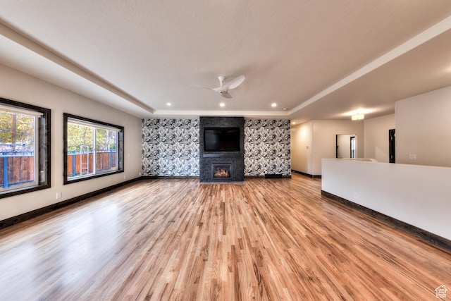 284 W Mcgill Blvd, Moab, UT 84532 - unfurnished living room with ceiling fan, a fireplace, a raised ceiling, light wood finished floors, and baseboards