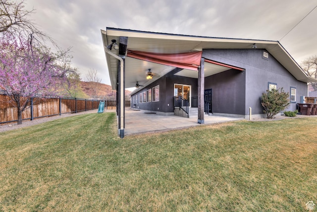 284 W Mcgill Blvd, Moab, UT 84532 - rear view of house featuring a patio, a yard, a fenced backyard, and stucco siding