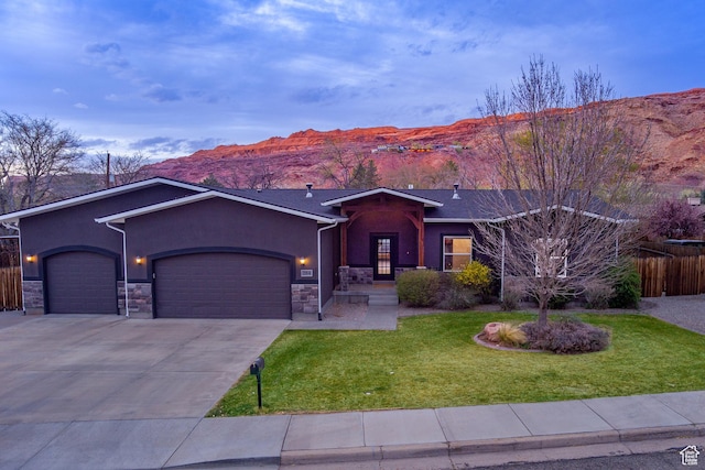 284 W Mcgill Blvd, Moab, UT 84532 - ranch-style home featuring a front yard, an attached garage, stone siding, and stucco siding