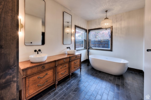 284 W Mcgill Blvd, Moab, UT 84532 - bathroom featuring a freestanding tub, double vanity, baseboards, and a sink