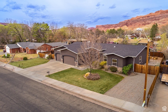 284 W Mcgill Blvd, Moab, UT 84532 - ranch-style house featuring driveway, stone siding, an attached garage, a front lawn, and fence