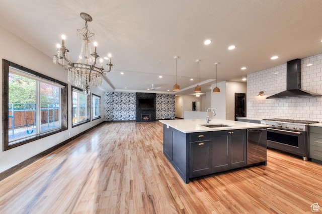 284 W Mcgill Blvd, Moab, UT 84532 - kitchen featuring a sink, wall chimney range hood, light countertops, light wood finished floors, and stainless steel appliances