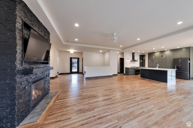 284 W Mcgill Blvd, Moab, UT 84532 - living room featuring light wood-style flooring, a fireplace, a ceiling fan, and baseboards