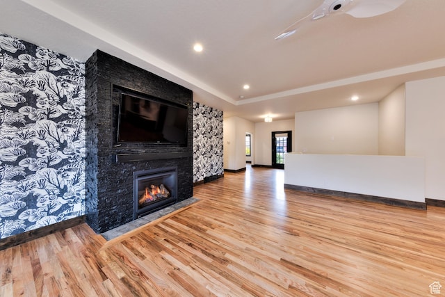 284 W Mcgill Blvd, Moab, UT 84532 - unfurnished living room with a fireplace with flush hearth, a raised ceiling, wood finished floors, and recessed lighting